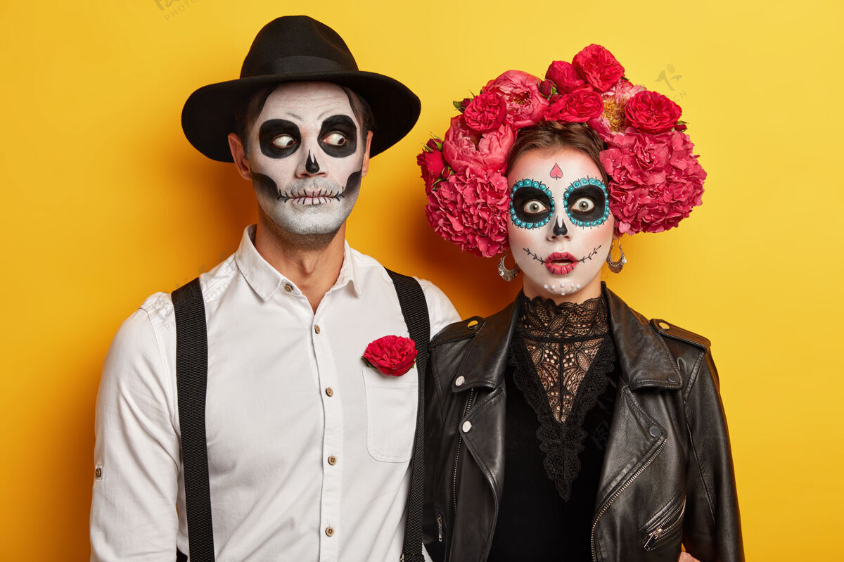 两个可怕的亡灵夫妇身着嘉年华服装 头骨化妆 红色花朵作为这一事件的象征花花环幽灵
