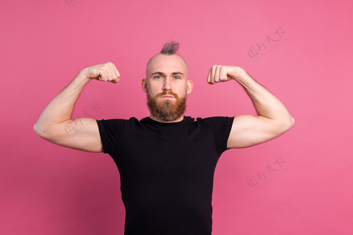 训练粉红色背景的强壮的欧洲男人展示肌肉男人自信健身房