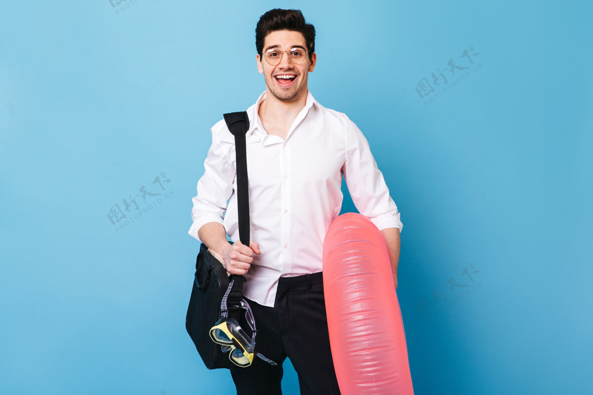 男性身穿白衬衫和黑裤子的黑发男人的肖像男人微笑着拿着橡皮圈 潜水面具和文件袋商务人士经理老板