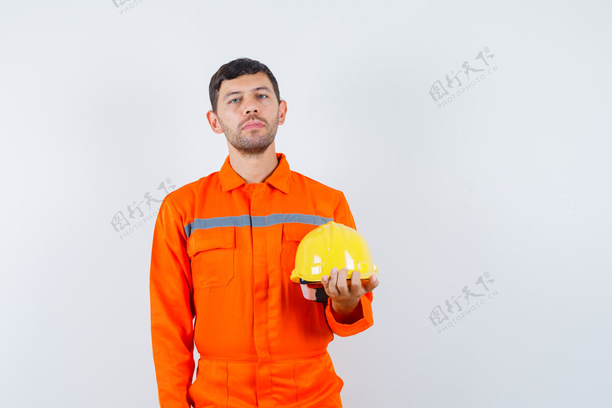 制服身着制服的工业工人手持头盔 神情平静 正前方观景操作工人头盔
