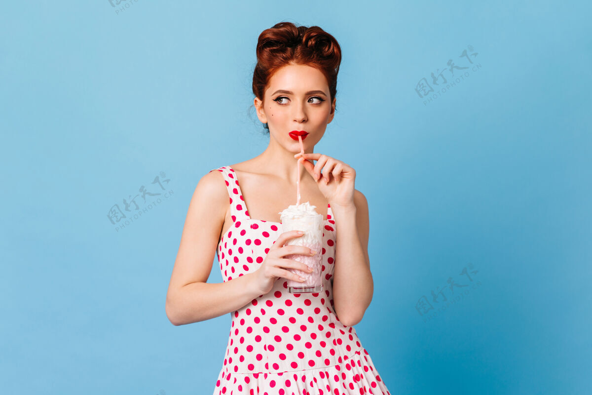 奶昔沉思的年轻女子喝着饮料姜汁小姑娘喝着奶昔的摄影棚镜头感性黑发时尚