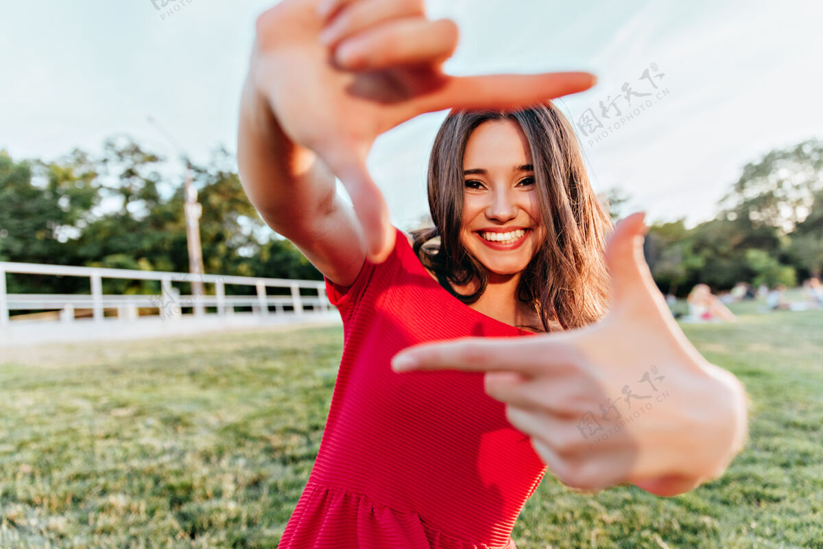 情绪美丽的黑发女孩在享受夏日的摄影美丽的女士在周末的公园里嬉戏草地享受表情