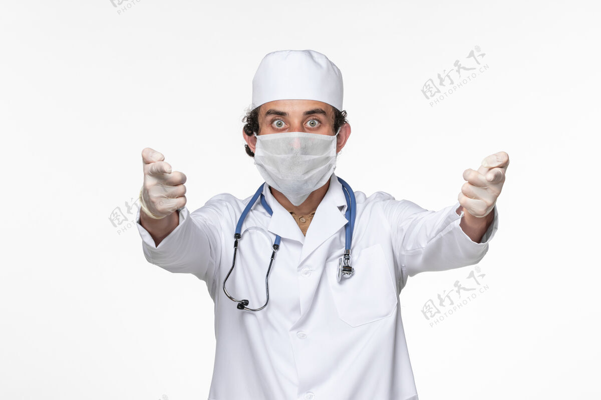 制服正面图男医生穿着医疗服 戴着无菌口罩 以防白墙病毒溅起冠状病毒大流行消毒病毒男人
