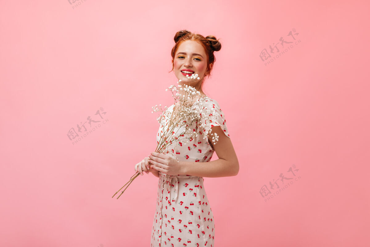 可爱身着迷笛裙和高跟凉鞋的可爱女士的全长照片粉色背景上手持白花的女士化妆头发简介