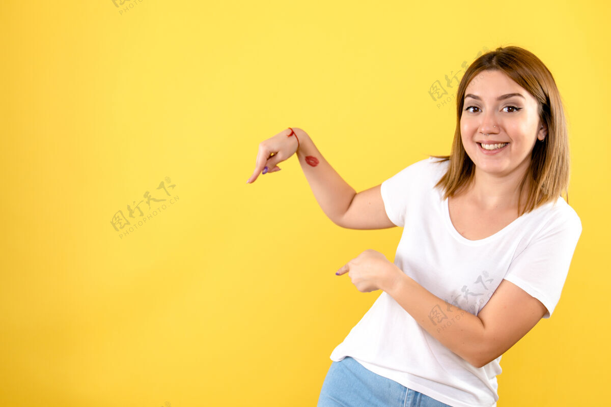 模特年轻女子在黄色墙上微笑的正面图快乐人人
