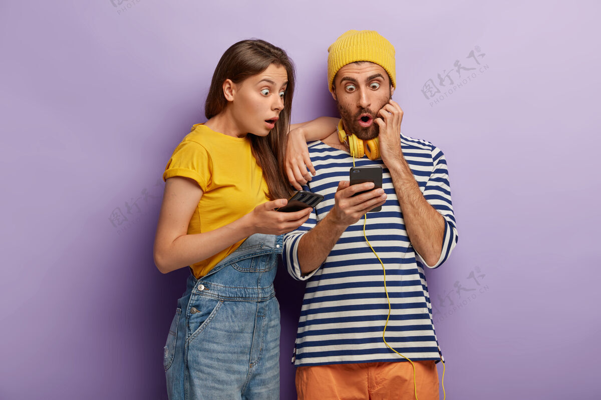 天哪一对被吓到的年轻夫妇在手机上看东西 被吓到了条纹年轻表情