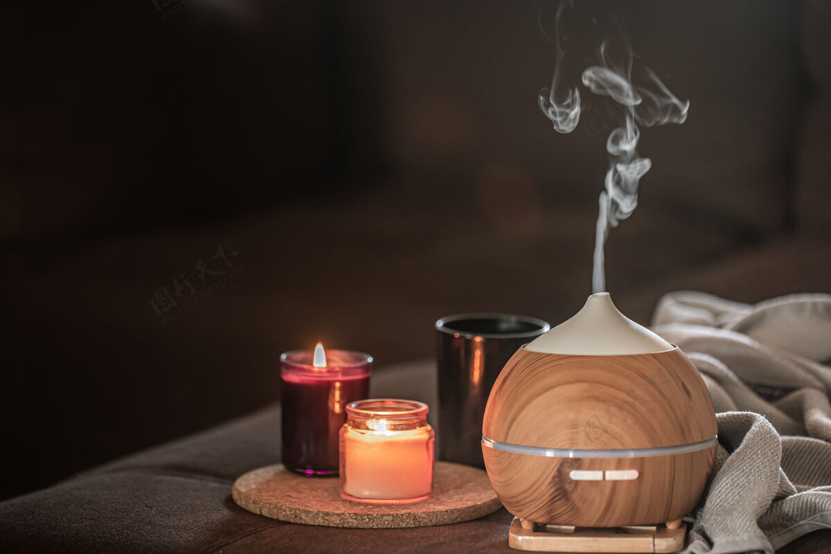 舒适蜡烛附近的模糊空间上的油扩散器香薰和保健概念蜡烛香气蒸汽