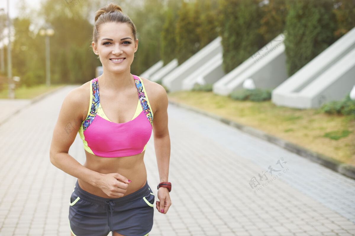 牙齿微笑年轻女子慢跑或户外跑步开始运动永远不嫌晚健身身体意识娱乐追求
