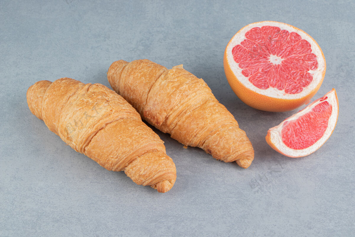 葡萄柚在大理石背景上切柚子和羊角面包高品质照片美味配料牛角包