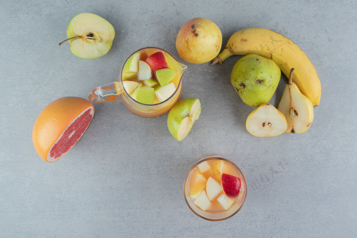 柚子大理石背景上有各种水果和一杯果汁高品质照片甜味水果糖
