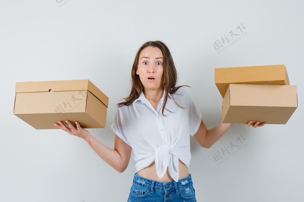 快乐美丽的女士拿着盒子 直接看着白色衬衫 看起来很担心前视图盒子忧虑时尚