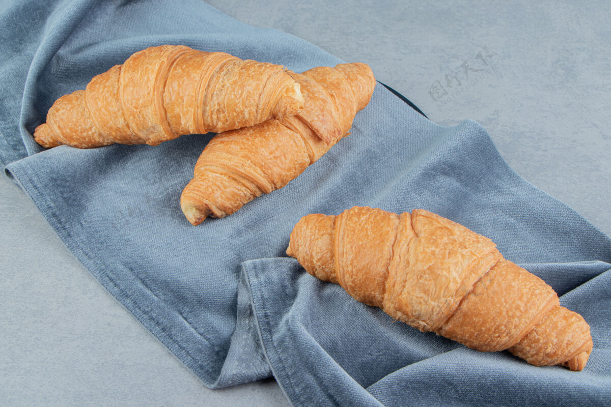 奶油美味的牛角面包在毛巾上 大理石背景上高品质的照片牛角包甜味毛巾