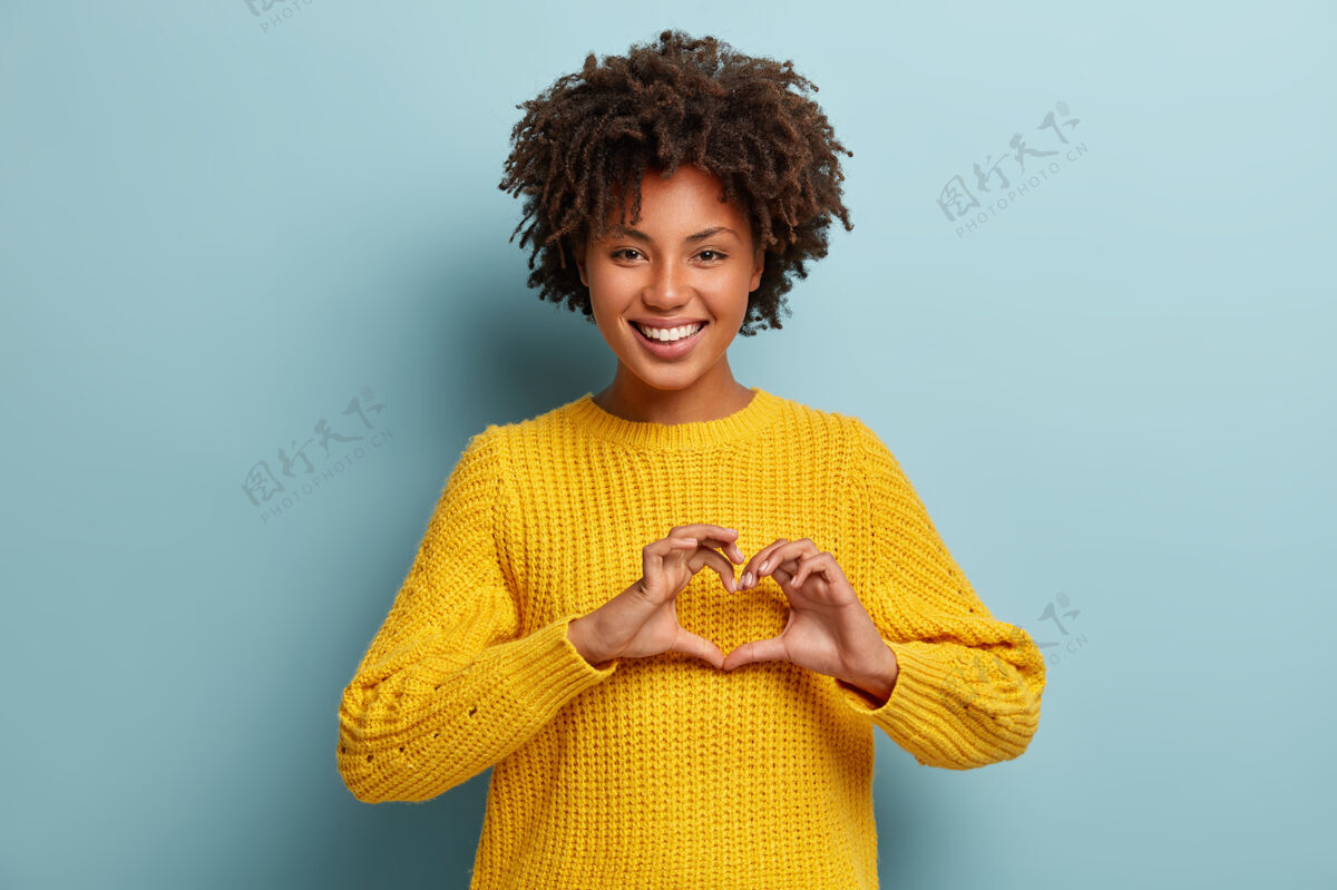 女人穿着粉色毛衣的非洲裔迷人女人积极女孩满意