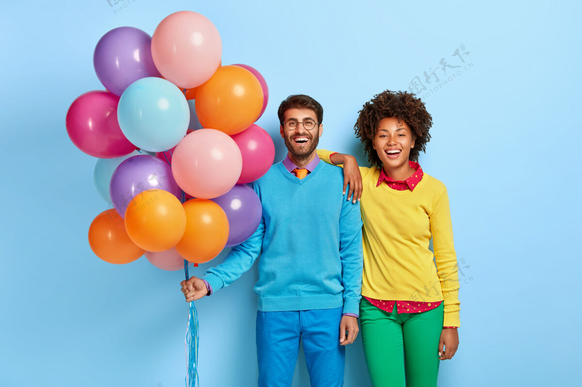 朋友一对年轻夫妇在派对上摆着气球举行眼镜五颜六色