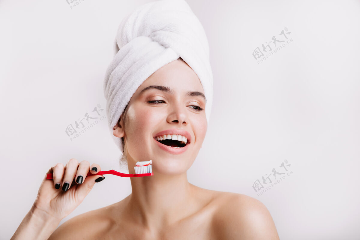 脸积极的女孩不化妆可爱的微笑在白墙上女人洗澡后刷牙闪亮保湿模特