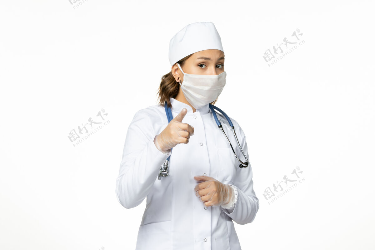 大流行正面图年轻女医生带着无菌口罩因白色表面有冠状病毒女性疾病冠状病毒
