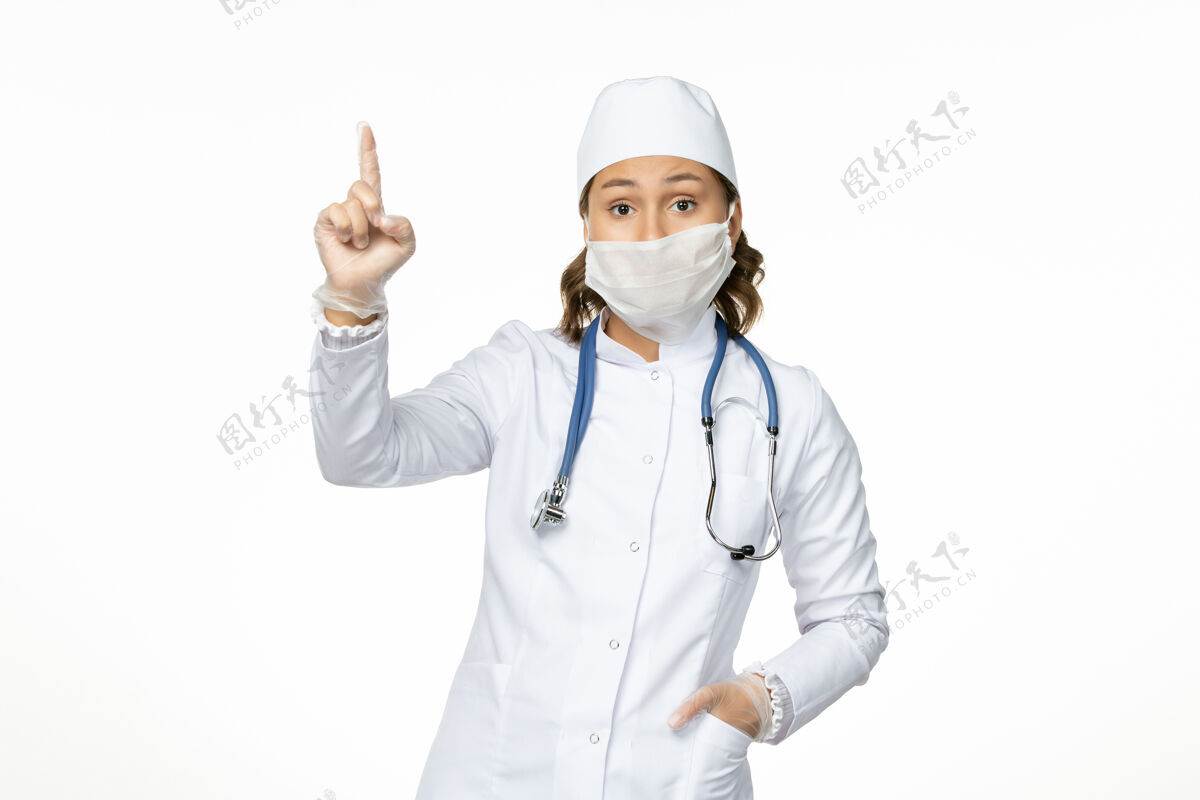 药品正面图年轻女医生穿着白色医疗服 戴着冠状病毒口罩在浅白的办公桌上到期前台疾病
