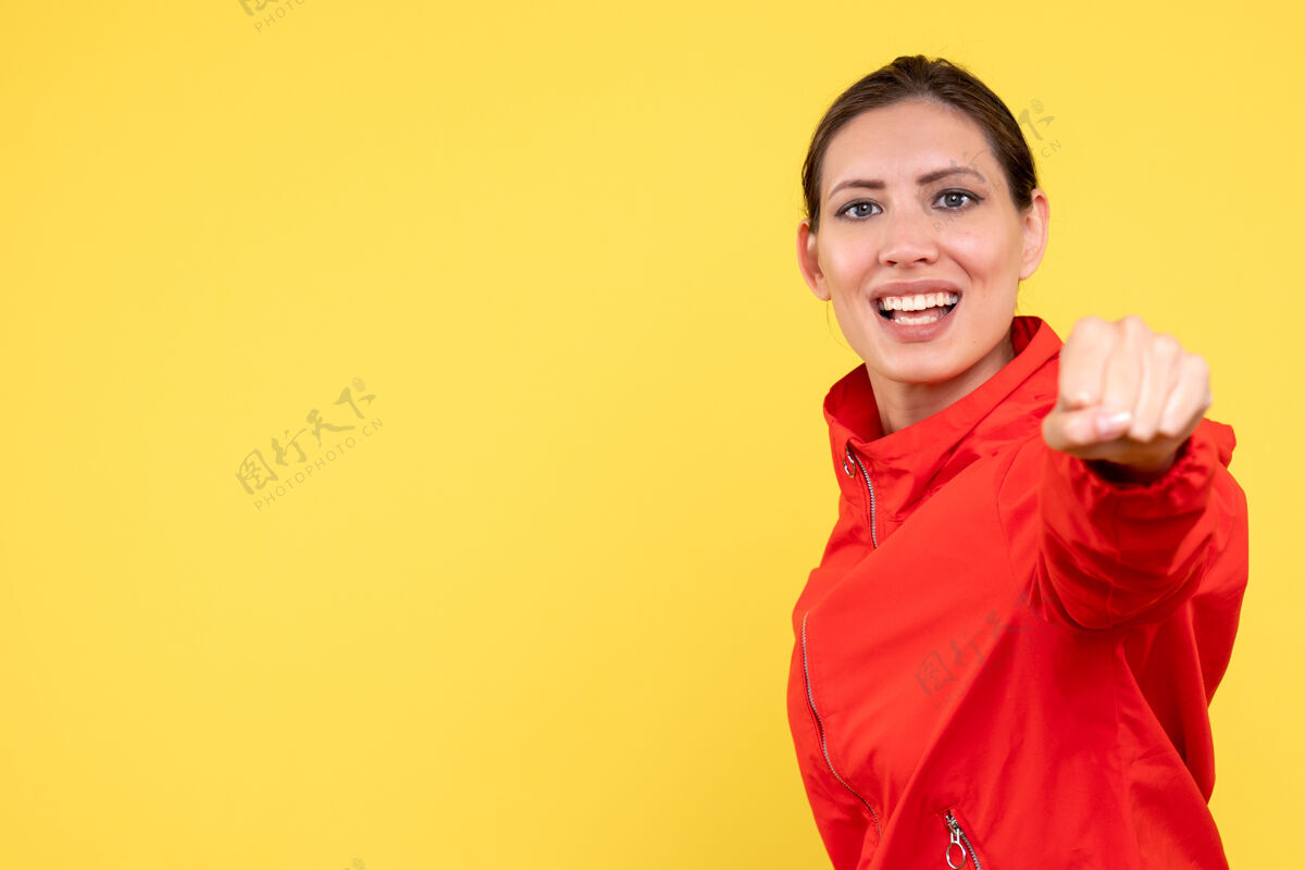 微笑正面图黄色背景上穿着红色外套的年轻女性运动肖像红色