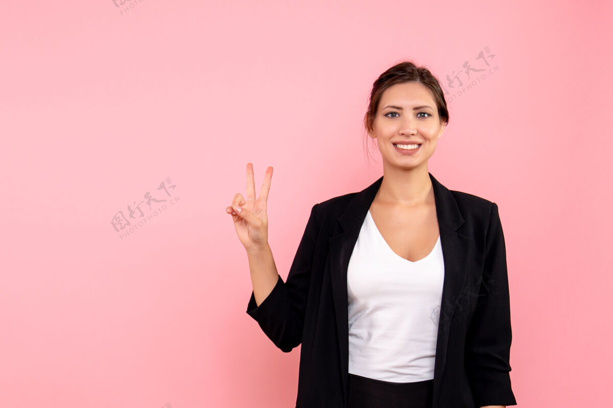 正面正面图年轻女性穿着粉色背景的深色夹克情感微笑商务女性