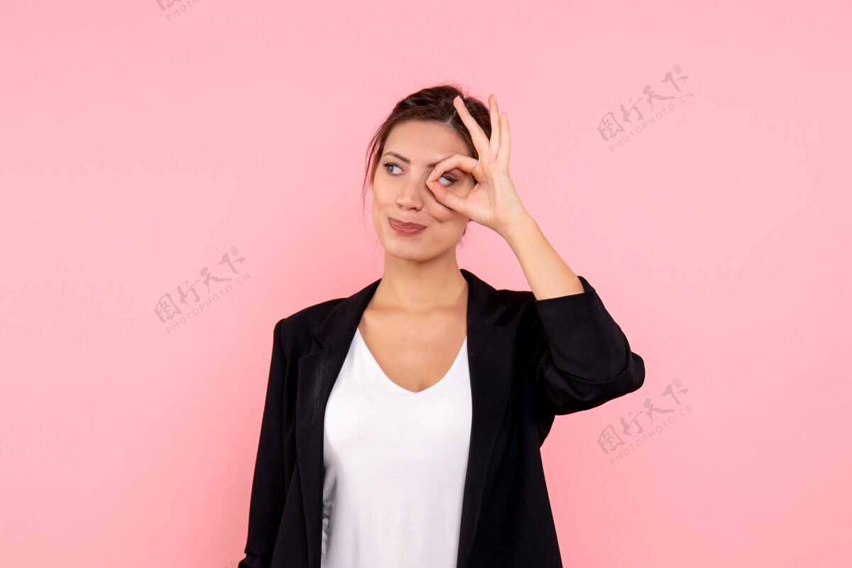 年轻女性正面图年轻女性穿着粉色背景的深色夹克粉色情感女士