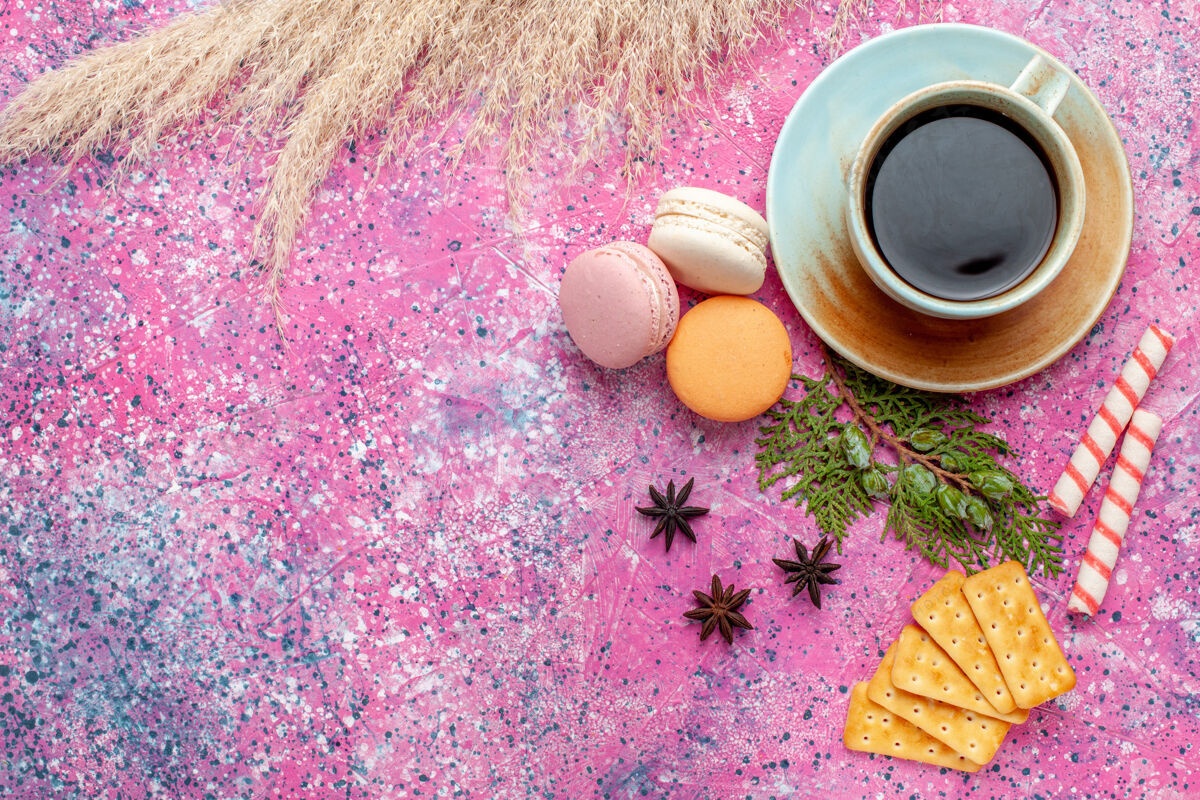 茶顶视图一杯茶 粉红色表面有饼干和麦卡龙邦邦生的顶部