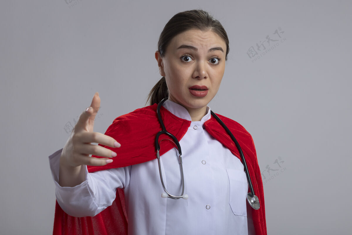 目录女医生手持听诊器 身穿白色医疗制服 身穿红色超级英雄斗篷 食指指着摄像机 站在白色的墙上 神情迷茫超级英雄人工作