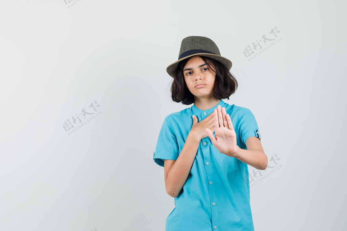 优雅一个穿着蓝色衬衫 戴着帽子 看起来很感激的年轻女士拒绝了什么东西积极黑发蓝色