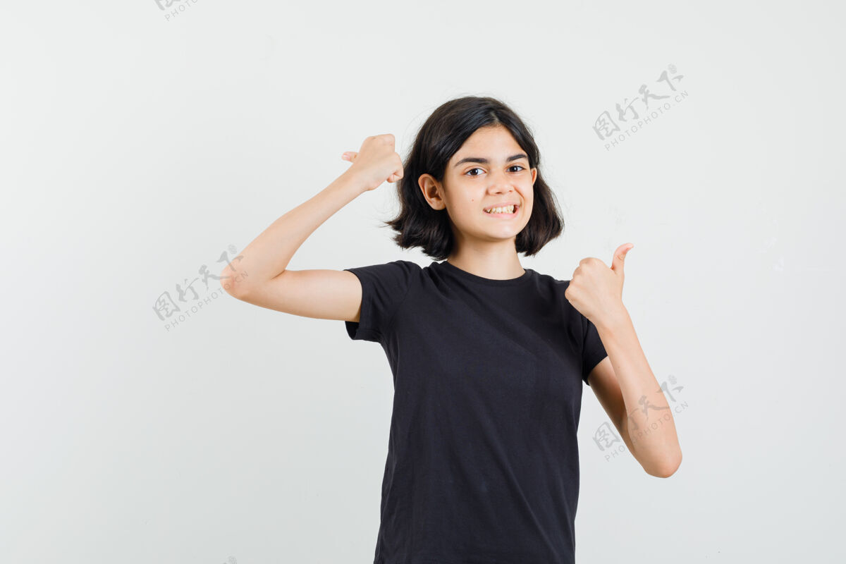 休闲身穿黑色t恤的小女孩向上竖起大拇指 看上去很欢快 正面视图外观欢快年轻