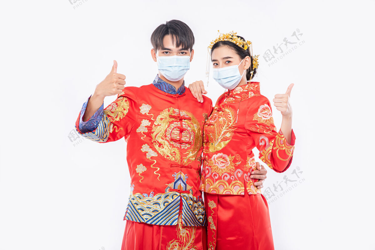 人男男女女穿旗袍西服戴口罩竖起大拇指庆祝活动将在农历新年举行竖起大拇指中国文化女孩