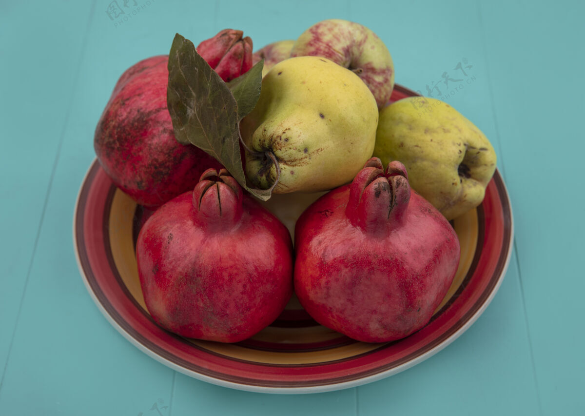 木瓜新鲜水果的俯视图 如石榴 木瓜和苹果在蓝色背景的碗上膳食苹果水果