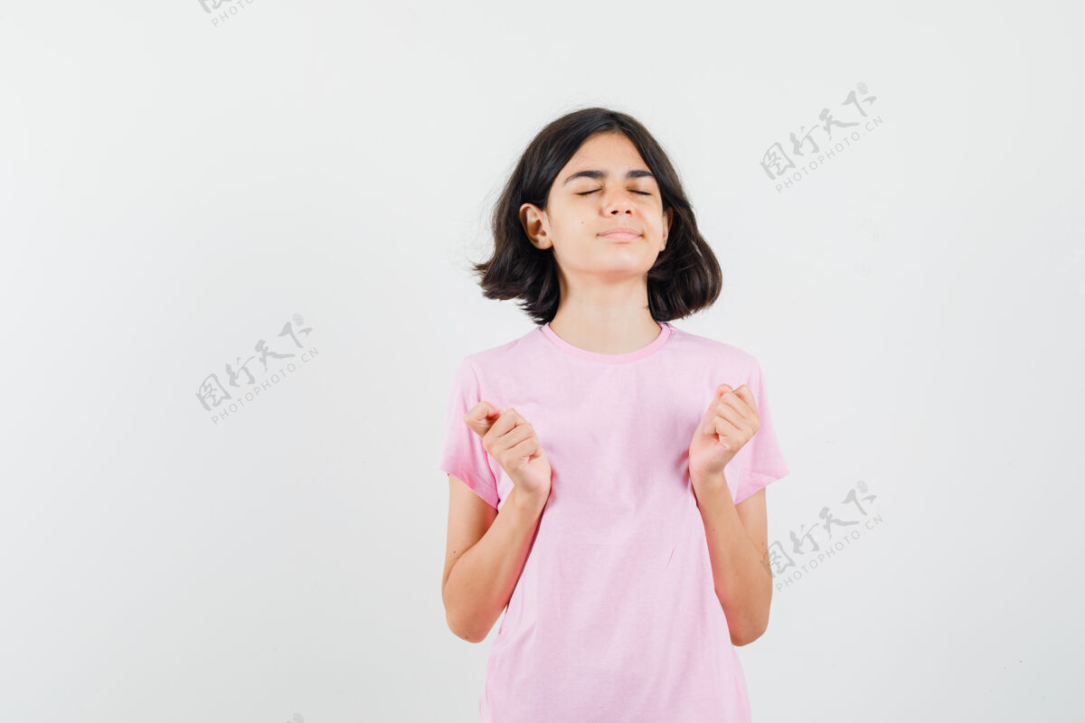 青少年小女孩做冥想闭上眼睛在粉红色的t恤衫 看起来和平 前视图外观美丽年轻
