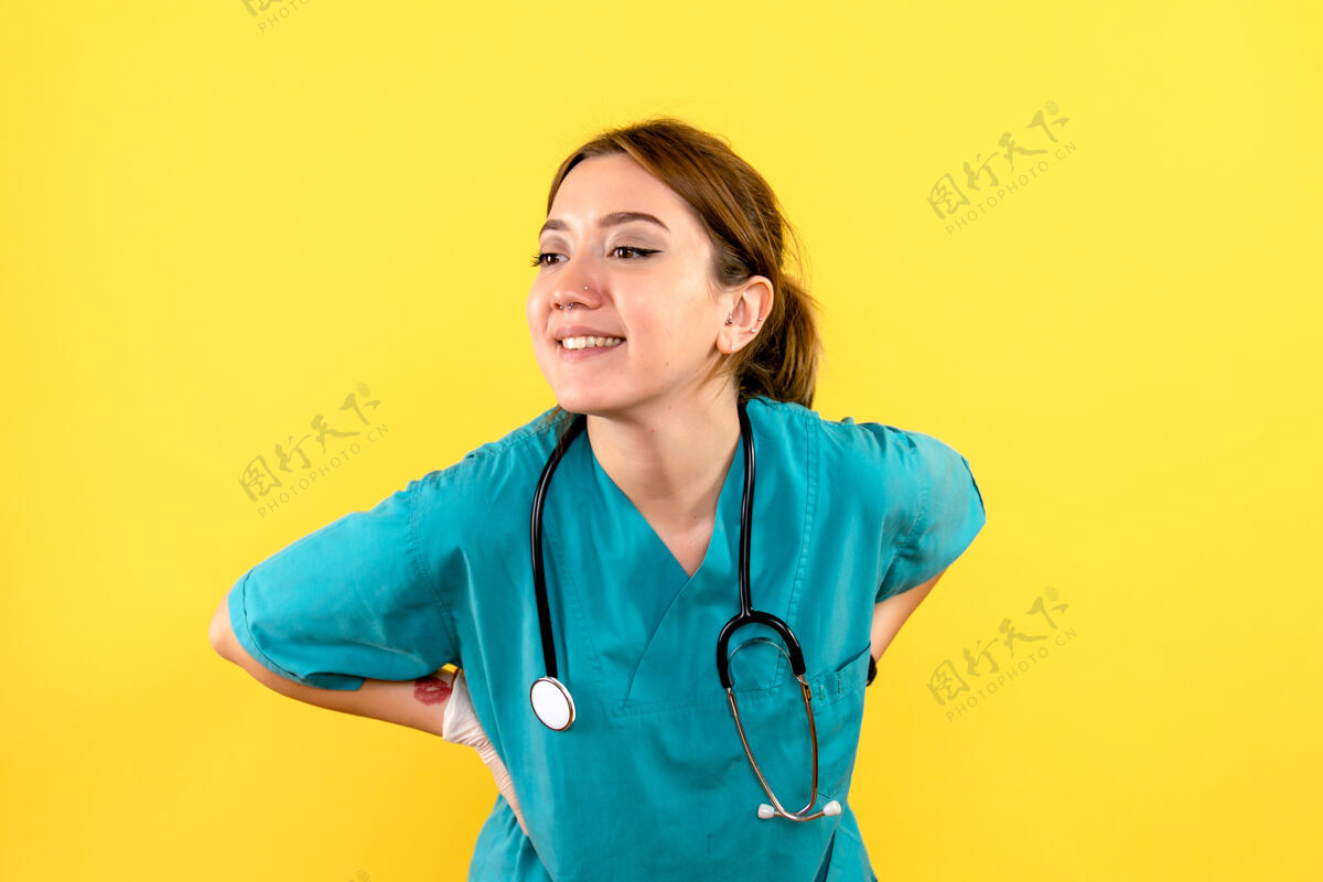 女兽医黄色墙壁上微笑的女兽医的正视图专家宠物药