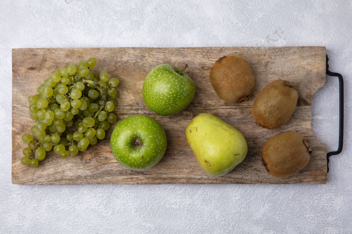 植物顶视图绿色葡萄与绿色苹果梨和猕猴桃在一个立场上反对一个白色的背景食品观点葡萄