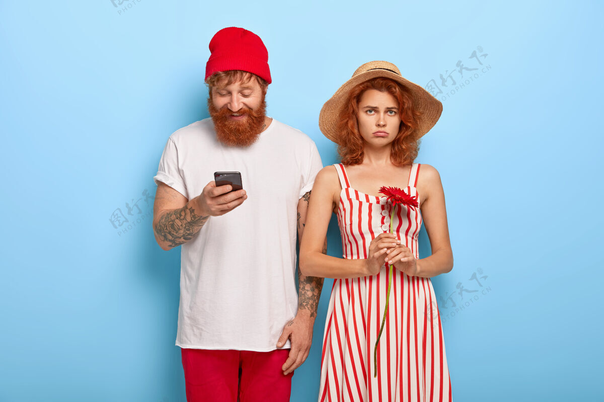 非洲菊当男朋友用手机时 不开心的红发女人感到无聊压力上瘾衣服