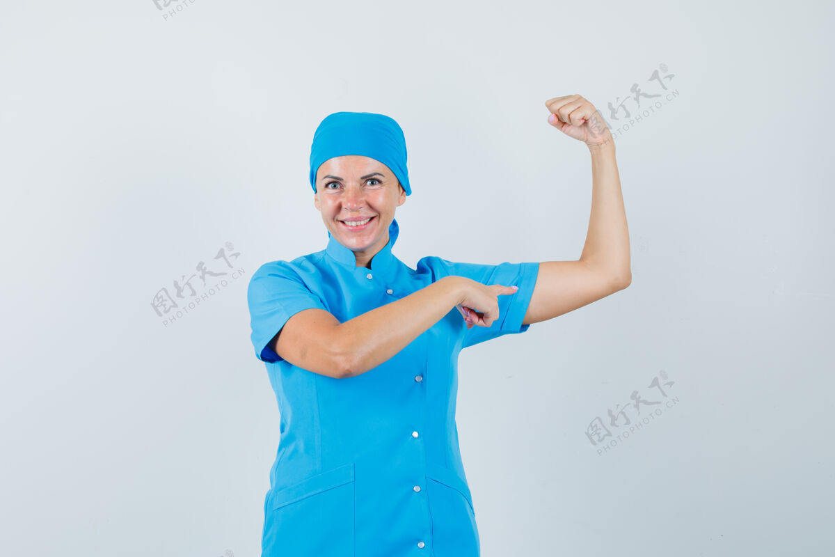 治疗女医生身着蓝色制服 指着手臂肌肉 神情自信 俯视前方医院诊所指点