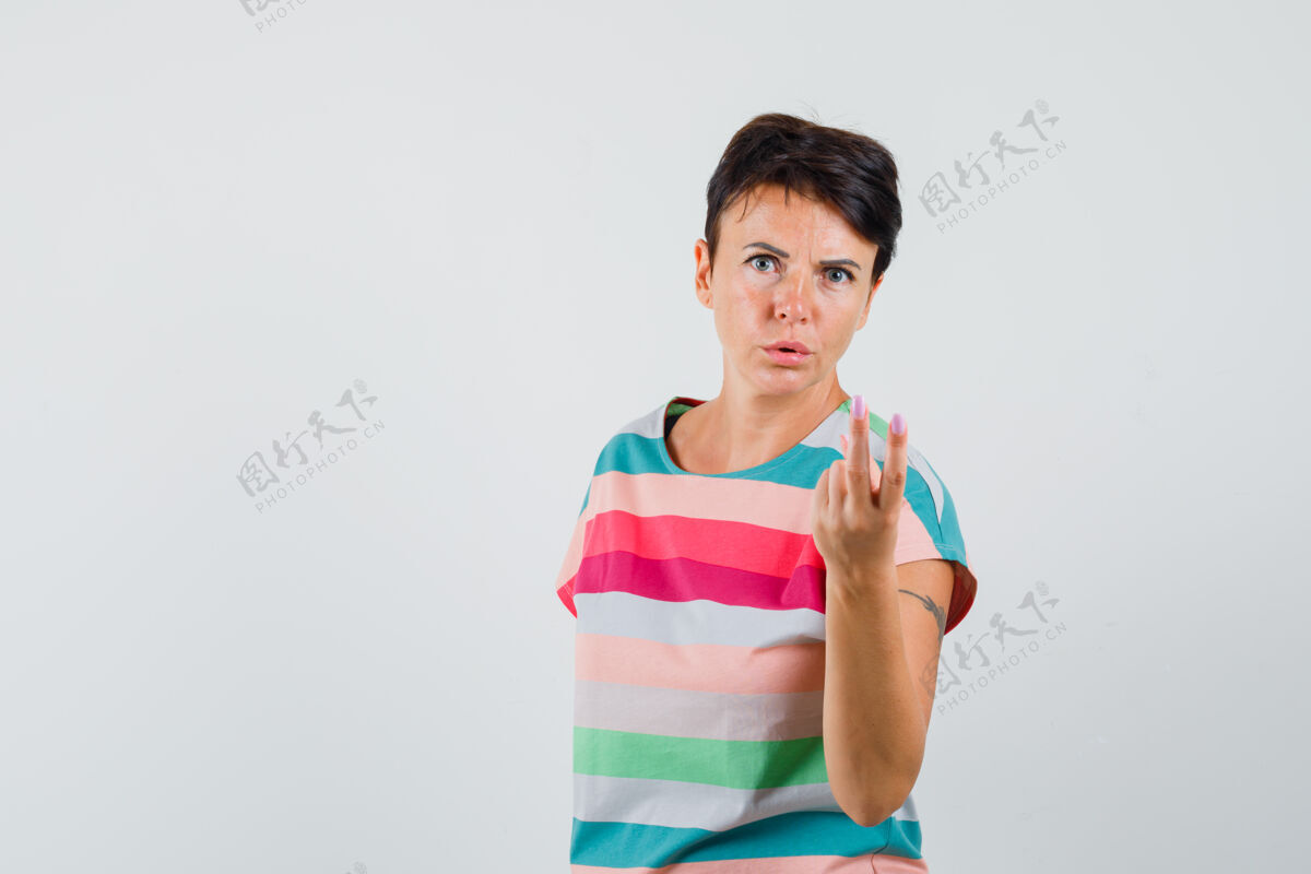 面罩女性穿着条纹t恤 露出两个手指 看起来很困惑 正面视图年轻爆发疾病
