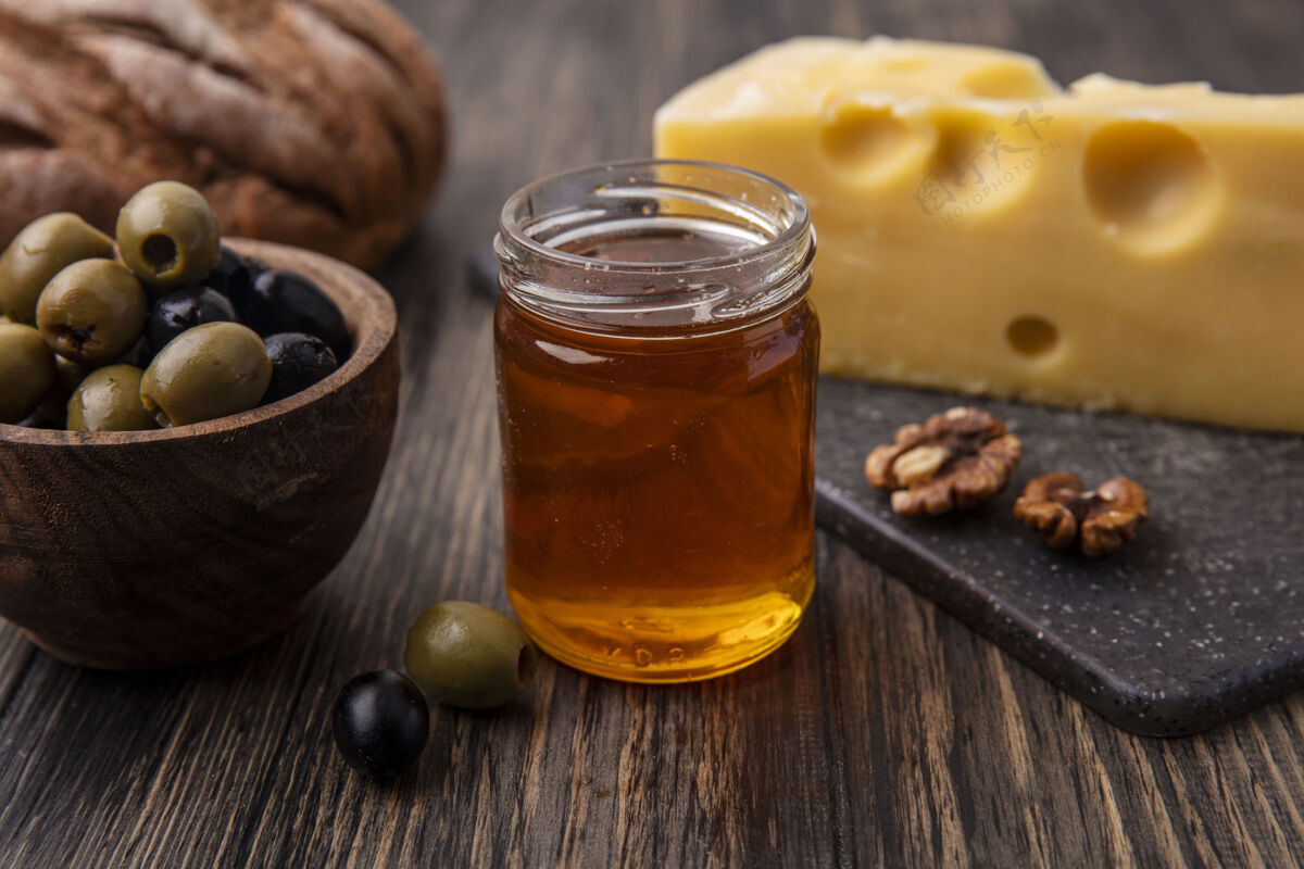 架子正面图蜂蜜放在一个罐子里 马斯丹奶酪放在架子上 橄榄放在桌子上餐桌橄榄正面