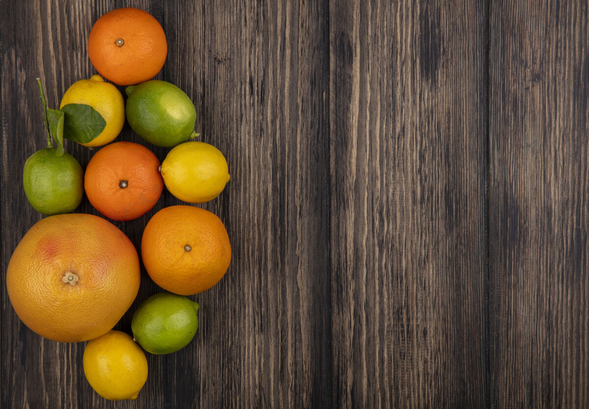 顶部顶视图复制空间葡萄柚与橙子柠檬和酸橙木背景复制水果柑橘