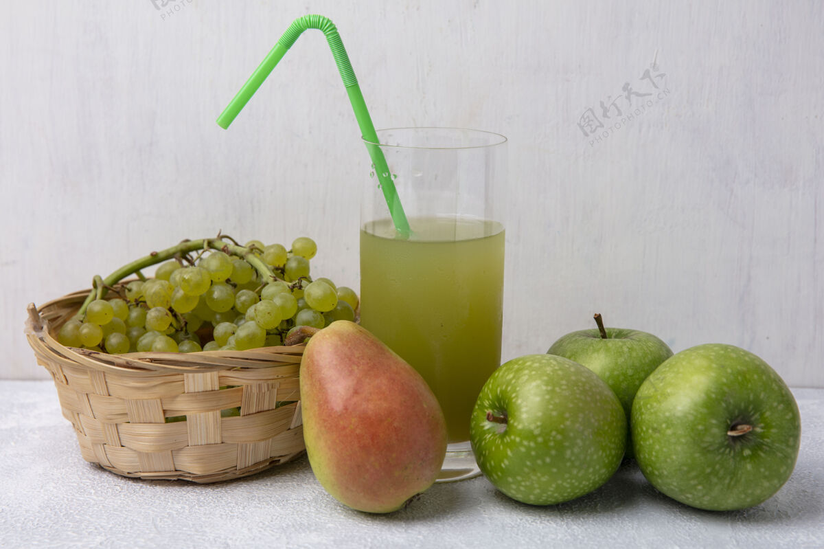 绿色前视图绿色葡萄在一个篮子与梨绿色苹果和苹果汁绿色吸管在一个白色的背景玻璃白色篮子苹果