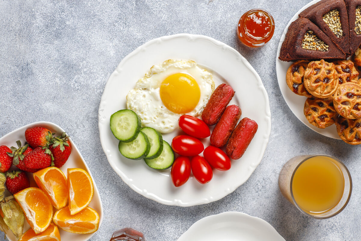 土耳其早餐盘子里有鸡尾酒香肠 煎蛋 樱桃番茄 糖果 水果和一杯桃子汁零食有机蔬菜