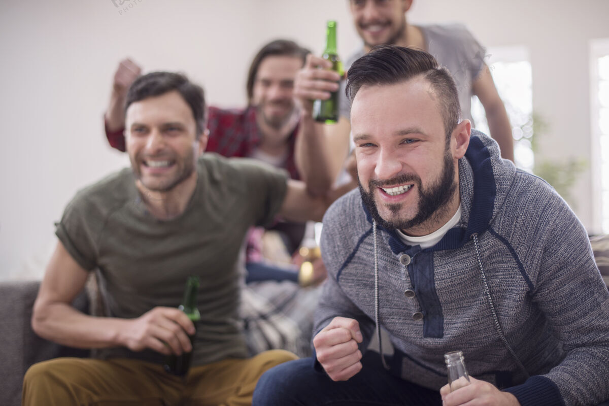 乐趣朋友们喝啤酒看足球赛坐着目标比赛