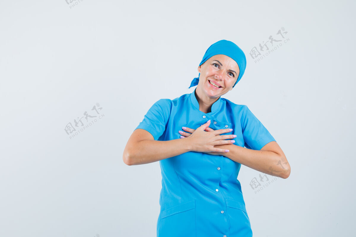 胸部女医生手放在胸前 身着蓝色制服 表情感激正视图实验室感激年轻人