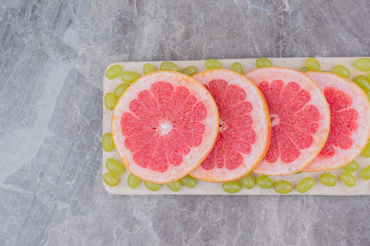 柚子柚子片和葡萄放在木板上柑橘健康天然