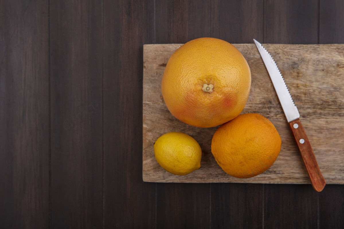 柠檬顶视图复制空间柠檬与橙色和葡萄柚在砧板与刀在木材背景柑橘视图切