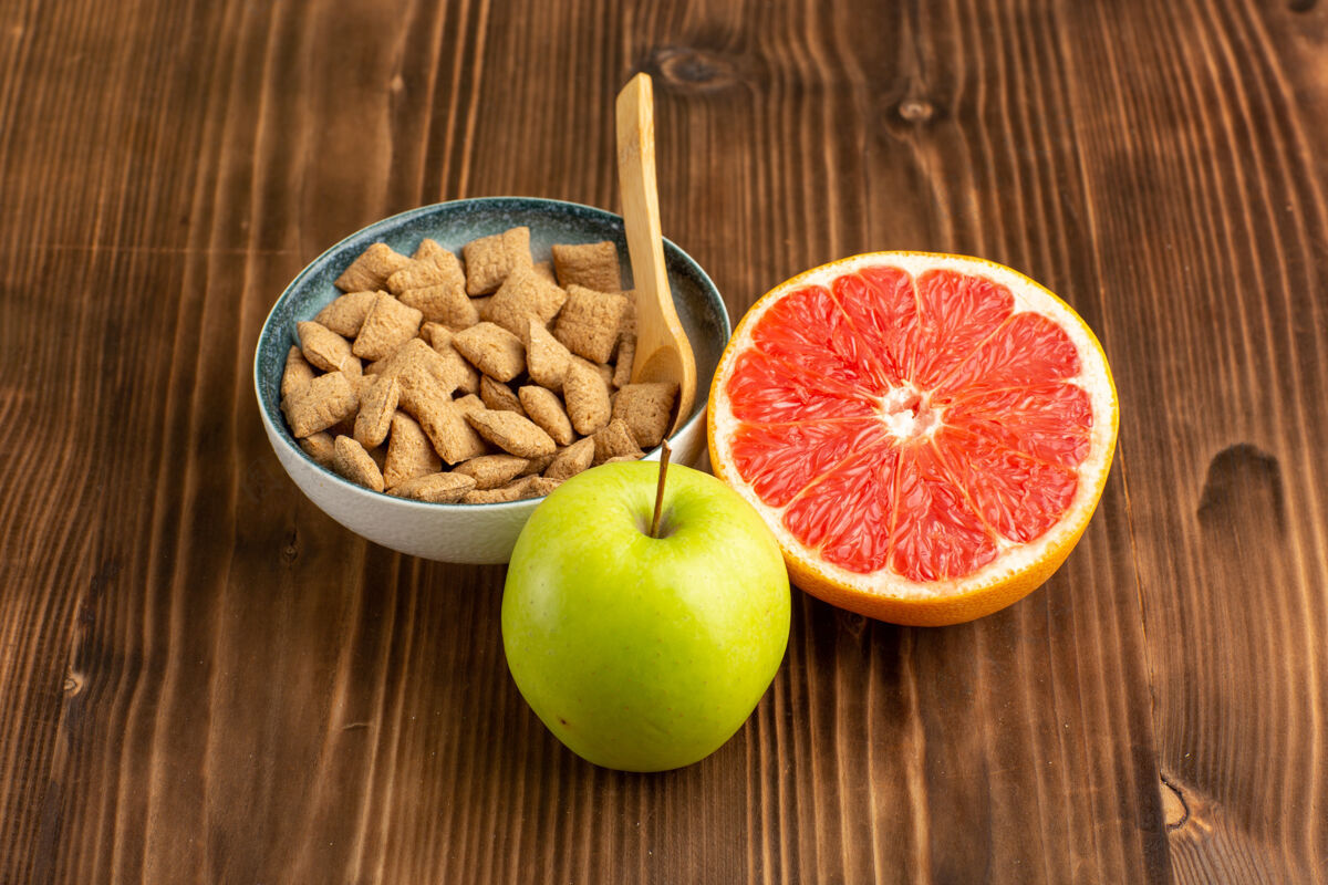 木头在棕色的木制书桌上可以看到葡萄柚和苹果的小饼干前面饼干苹果