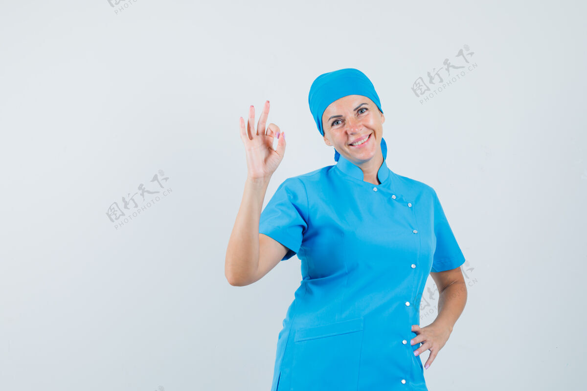 女人女医生穿着蓝色制服做着正常的姿势 看起来很自信 正前方手势治疗成人