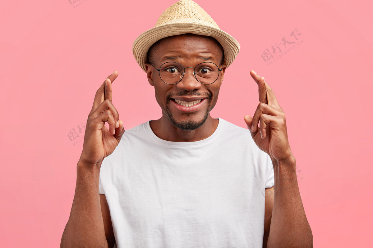 交叉有趣的积极的非洲裔美国中年男性交叉手指墙壁人类帽子