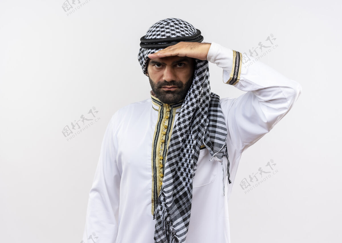 手穿着传统服装的阿拉伯男人远远望去 手举着头站在白墙上头穿阿拉伯语