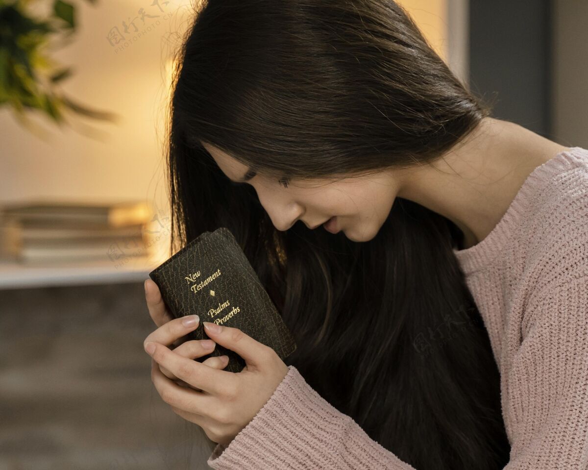 圣经妇女手持圣经祈祷的侧视图信仰信条女人