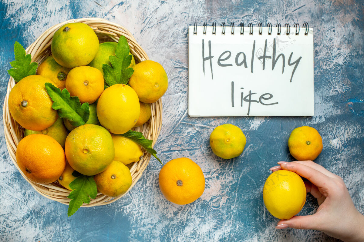 柳条顶看柳条筐上的新鲜柑桔健康生活写在记事本上普通话在女人手上蓝白色的表面顶部柑橘国语